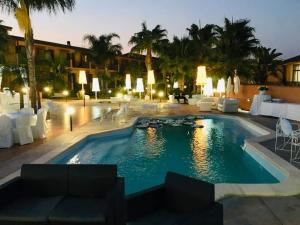 a pool at a hotel at night at Hotel Villa Peretti in Gela