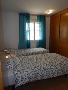 1 dormitorio con 1 cama y una ventana con cortinas azules en 2-bedroom Villa with pool en Torre-Pacheco