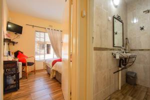 a bathroom with a sink and a bedroom with a bed at All over Africa Guest house in Kempton Park +58 photos