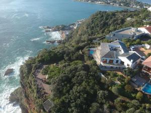 een luchtzicht op een huis op een heuvel naast de oceaan bij Knysna Pearl View Guest House in Knysna