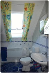 a bathroom with a toilet and a sink and a window at Ferienhaus Naturblick am Tor zum Nationalpark Kellerwald in Frankenau