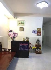 a waiting room with flowers and a sign on the wall at Nhà nghỉ Hoàng Huân in Long Xuyên