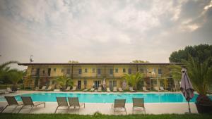 a building with a pool and chairs and an umbrella at Agriturismo Dolce Luna in Milan