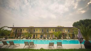 un edificio con piscina, sillas y sombrilla en Agriturismo Dolce Luna en Milán