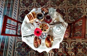einen Tisch mit einem Teller Gebäck und Desserts darauf in der Unterkunft B&B Cose Belle in Capurso