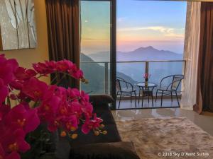 a room with a couch and a balcony with a view at Sky D'Mont Suites in Genting Highlands