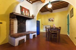 ein Wohnzimmer mit einem Kamin und einem Tisch in der Unterkunft Foresteria del Teatro Povero in Monticchiello