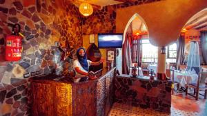 a man standing at a counter in a restaurant at Riad Chay & Boutique in Ouarzazate