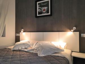 a bedroom with a large bed with lights on it at ASV Apartments in Pineda de Mar