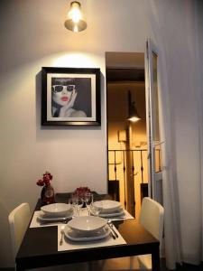a dining room table with a picture of a woman at ASV Apartments in Pineda de Mar