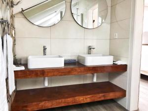 a bathroom with two sinks and a mirror at Hotel pas de Cheville in Conthey