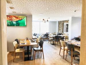 a dining room with tables and chairs in a restaurant at Hotel pas de Cheville in Conthey