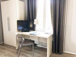 einen Schreibtisch mit einem Computer, einem Monitor und einem Fenster in der Unterkunft Hotel pas de Cheville in Conthey