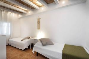 a bedroom with two beds and a cross on the wall at Can Terrats in Blanes
