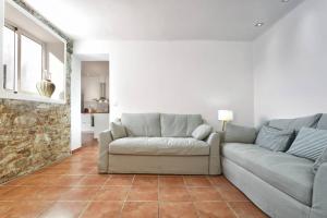 a living room with a couch and a stone wall at Can Terrats in Blanes
