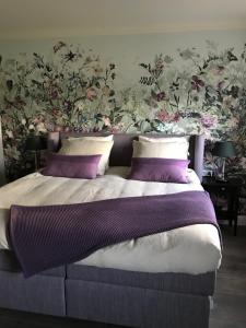 a bedroom with a large bed with purple pillows at B&B Holset70 in Lemiers +84 photos