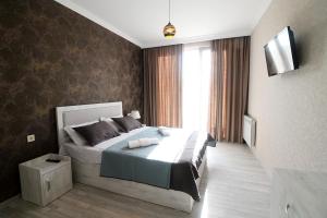 a bedroom with a bed and a large window at Friendship House in Tbilisi City