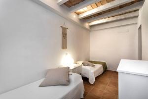 two beds in a room with white walls at Can Terrats in Blanes