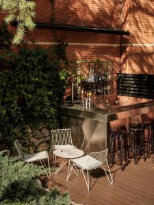 - un bar avec des chaises blanches et un comptoir avec des boissons dans l'établissement Hotel Balmes, a member of Preferred Hotels & Resorts, à Barcelone