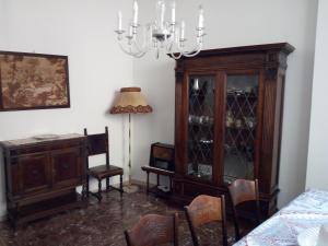 une salle à manger avec un lustre et un meuble en bois dans l'établissement Appartamento Centro Storico vicino Università, à Pérouse