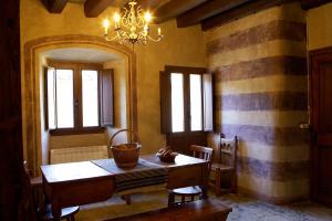 a dining room with a table and chairs and a chandelier at Poble Rural Puig Arnau - Pubilló in Oden