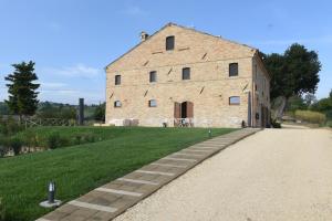 un grand bâtiment en briques avec un sentier devant lui dans l'établissement Villa Shmitanka, à Servigliano