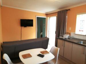 ein Wohnzimmer mit einem Tisch und einem Sofa in der Unterkunft Lovely Linden Cottage with Solar Inverter in Johannesburg