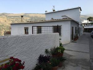 una casa blanca con plantas delante en CASA ALBA E IRENE, en Bubión