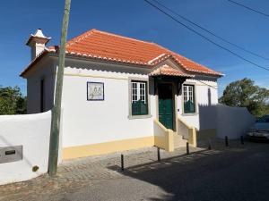 mały biały dom z zielonymi drzwiami w obiekcie Entire House - Romantic Vintage Cottage w mieście Sintra