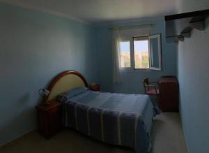 - une chambre bleue avec un lit et une fenêtre dans l'établissement Apartamentos San Miguel 2, à Almerimar