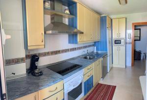 a kitchen with blue and white cabinets and a sink at Apartamentos San Miguel 2 in Almerimar