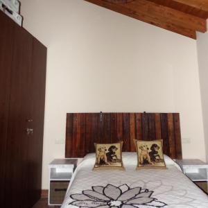 um quarto com uma cama com uma cabeceira em madeira e 2 almofadas em PENDAN DE GREDOS em San Martín del Pimpollar