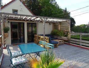 a deck with a ping pong table and a pergola at Casa Juno in Duvy