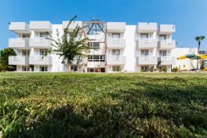 a large white building with a lawn in front of it at Vagelis Apartments Malia in Malia