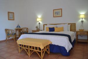 1 dormitorio con 1 cama grande con almohadas azules y amarillas en Parador Boquemar, en Boquerón