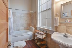 a bathroom with a tub and a sink and a toilet at Elysian Fields Inn in New Orleans