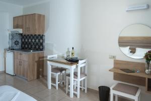 a small kitchen with a table and chairs in a room at Vagelis Apartments Malia in Malia