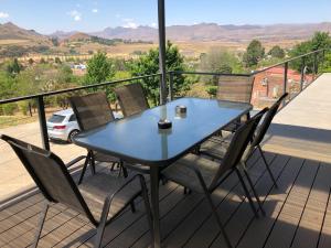 a blue table and chairs on a balcony with a view at Lola's Self Catering Accommodation in Clarens