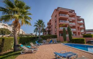 a resort with a pool and lounge chairs and a building at B02 - Fantastic Apartment with Pool in Portimão