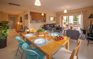 een keuken en een woonkamer met een tafel en stoelen bij B02 - Fantastic Apartment with Pool in Portimão