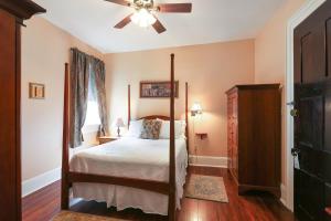 a bedroom with a four poster bed and a ceiling fan at Elysian Fields Inn in New Orleans