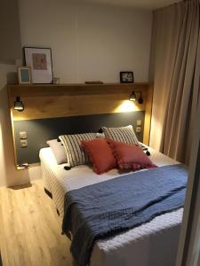 - une chambre avec un grand lit et une tête de lit en bois dans l'établissement Camping Dun-le-Palestel, à Dun-le-Palestel