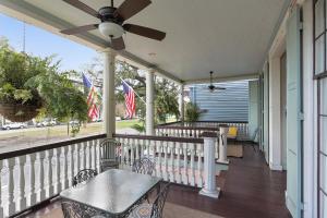 a porch with a ceiling fan and a table at Elysian Fields Inn in New Orleans