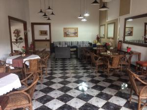 a restaurant with tables and chairs and a checkered floor at Pousada Aguas de Ibira in Termas do Ibirá