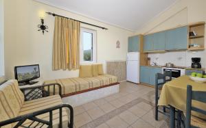 eine Küche und ein Wohnzimmer mit einem Sofa und einem Tisch in der Unterkunft Paris Village Apartments in Chrani