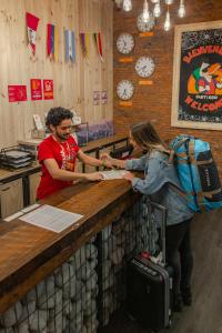 un homme et une femme debout dans un bar dans l'établissement Pariwana Hostel Santiago, à Santiago