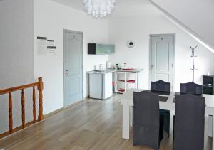 a kitchen and dining room with a table and a kitchen with a refrigerator at Villa Vivian in Szczecin