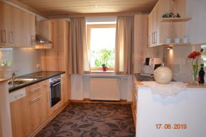 a kitchen with wooden cabinets and a window at Panorama in Sulzberg