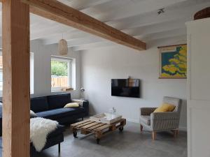 Una sala de estar con un sofá azul y un televisor. en De Bonte beleving, en Oostkapelle