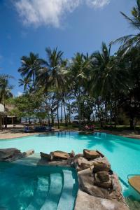 a large swimming pool with palm trees in the background at Severin Sea Lodge in Mombasa